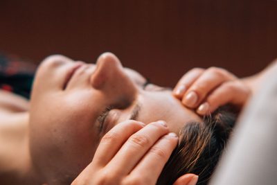 Kopfhautmassage bei einer liegenden Person